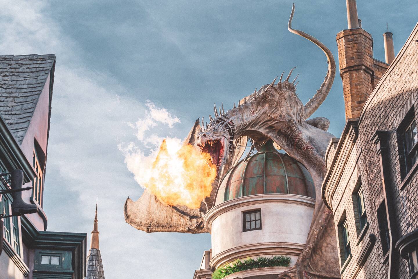 Dragon atop a wizarding-themed bank facade at a nearby theme park